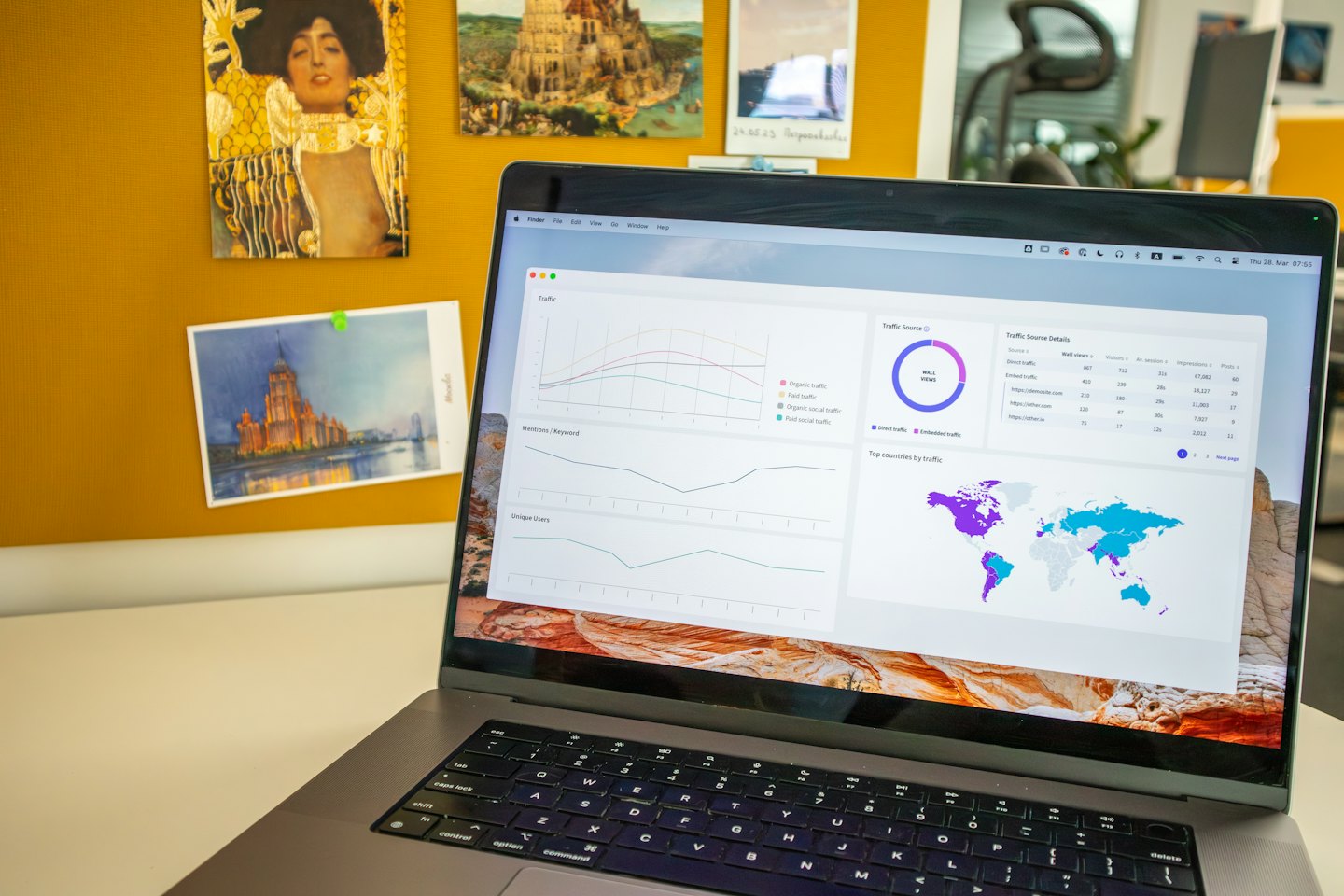 Laptop con dashboard di analisi dati su una scrivania.