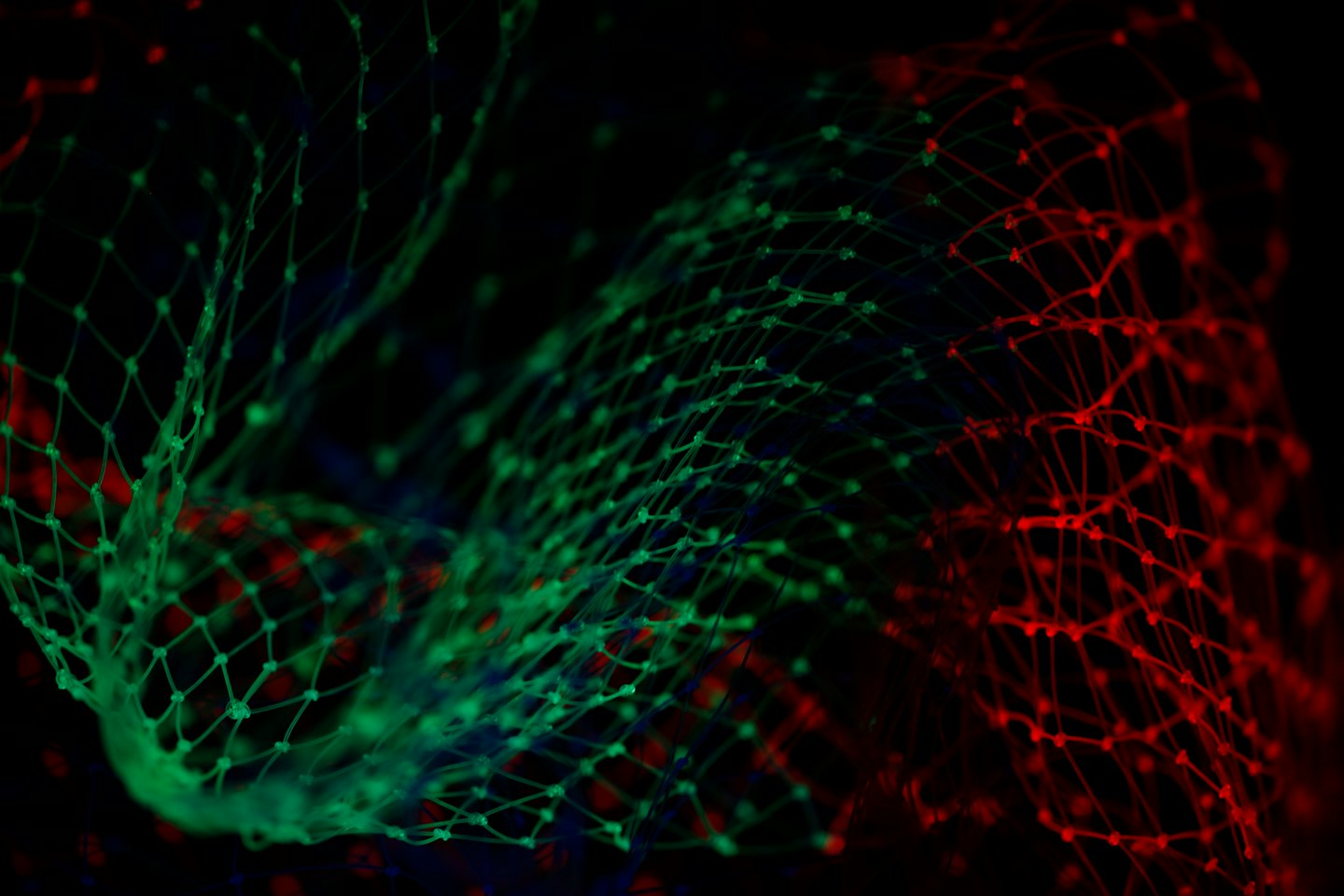 Rete digitale luminosa verde e rossa su sfondo nero.